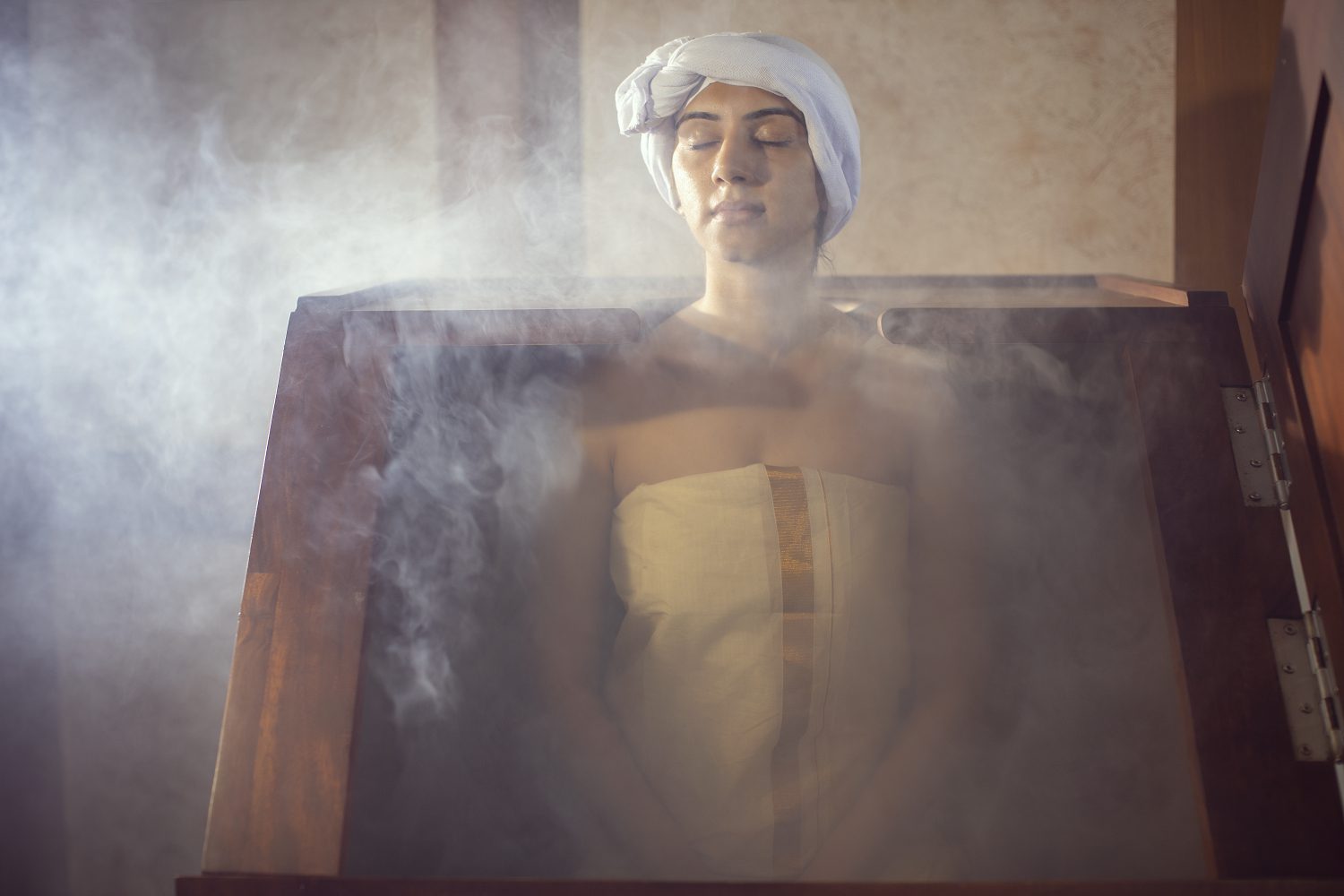Eine Gästin genießt eine traditionelle Swedana-Dampfbadbehandlung im Amal Tamara Ayurveda Resort.