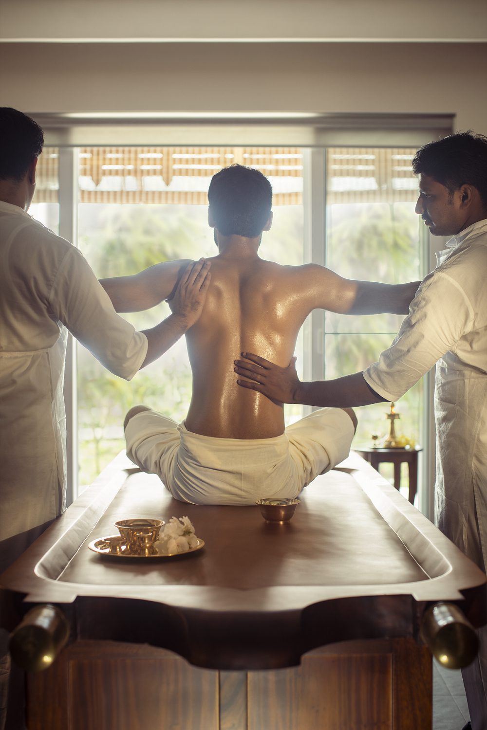 Zwei Therapeuten führen im Amal Tamara eine traditionelle Ayurveda-Synchronmassage durch.