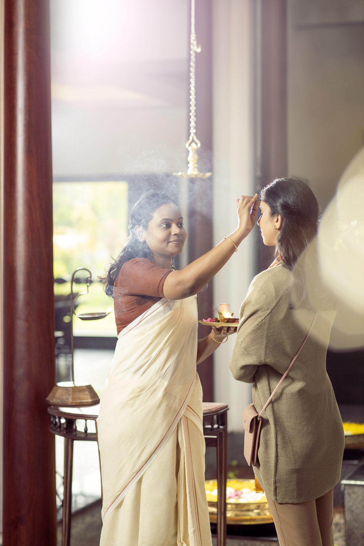 Eine Mitarbeiterin des Amal Tamara empfängt einen Gast mit einem traditionellen ayurvedischen Willkommensritual.